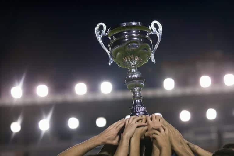 Soccer Team Raising Trophy --- Image by © Royalty-Free/Corbis