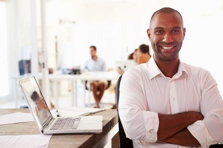 Man Using Laptop In Modern Office Of Start Up Business Man Using Laptop In Modern Office Of Start Up Business