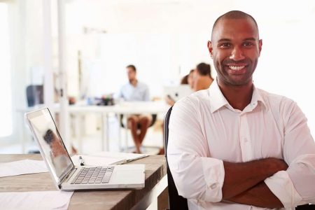 Man Using Laptop In Modern Office Of Start Up Business Man Using Laptop In Modern Office Of Start Up Business